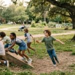 Children enjoying unstructured play outdoors while their mom watches nearby